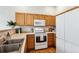 Well-lit kitchen with laminate countertops, wooden cabinets and white appliances at 2870 W Riverwalk Cir # B, Littleton, CO 80123