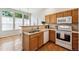 Functional kitchen with stainless steel sink, white appliances and hardwood floors at 2870 W Riverwalk Cir # B, Littleton, CO 80123