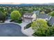 Aerial shot of a property highlighting its well-manicured lawn, a three-car garage, and neighborhood at 6973 Daventry Pl, Castle Pines, CO 80108