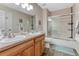 Bathroom featuring a double vanity, tiled floors, and a shower-tub combination, creating a functional space at 6973 Daventry Pl, Castle Pines, CO 80108