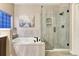 Updated bathroom featuring a soaking tub, glass-enclosed shower, and a vanity with plenty of counter space at 6973 Daventry Pl, Castle Pines, CO 80108