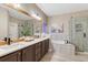 Elegant bathroom with double vanity, soaking tub, glass-enclosed shower, and modern fixtures at 6973 Daventry Pl, Castle Pines, CO 80108