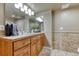 Bathroom featuring a vanity with a wooden finish, a large mirror, and decorative plants at 6973 Daventry Pl, Castle Pines, CO 80108