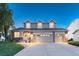 Inviting two-story home featuring a brick facade and a spacious three-car garage at 6973 Daventry Pl, Castle Pines, CO 80108