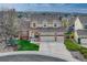 Beautiful two-story home featuring a three-car garage, manicured lawn, and professionally landscaped surroundings at 6973 Daventry Pl, Castle Pines, CO 80108
