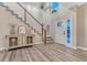 Inviting foyer with wood floors, staircase, and plenty of natural light at 6973 Daventry Pl, Castle Pines, CO 80108
