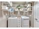 Bright laundry room with front-loading washer and dryer, wire shelving, and storage at 6973 Daventry Pl, Castle Pines, CO 80108