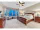 Cozy main bedroom with large bay window, carpeting, a ceiling fan, and furnishings at 6973 Daventry Pl, Castle Pines, CO 80108