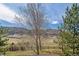 Scenic backyard view showing landscaping and fencing against a backdrop of rolling hills and blue skies at 9836 W Freiburg Dr # 4E, Littleton, CO 80127