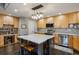Bright kitchen showcases an island with seating, stylish lighting, stainless steel appliances, and wood cabinetry at 9836 W Freiburg Dr # 4E, Littleton, CO 80127