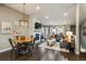 Open-concept living and dining area featuring hardwood floors, modern lighting, and a cozy fireplace with marble surround at 9836 W Freiburg Dr # 4E, Littleton, CO 80127