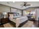 Inviting main bedroom with a large bed, ceiling fan, and a dedicated desk space by the window at 9836 W Freiburg Dr # 4E, Littleton, CO 80127