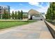 Open-air amphitheater in a park with green grass, tall trees, and paved walkways under a blue sky at 7700 E 29Th Ave # 404, Denver, CO 80238