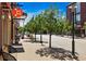 Street view featuring vibrant businesses, pedestrian-friendly sidewalks, and lush trees on a sunny day at 7700 E 29Th Ave # 404, Denver, CO 80238