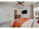 Well-lit bedroom with TV, view into ensuite bath, and a neutral palette at 2607 W 24Th Ave, Denver, CO 80211