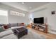 Modern living room with a large gray sectional, hardwood floors, and a wall-mounted TV at 2607 W 24Th Ave, Denver, CO 80211