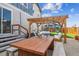 Inviting backyard featuring a wooden pergola over an outdoor table and seating area, ideal for entertaining at 5687 Dayton St, Denver, CO 80238