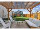 Relaxing backyard featuring a wooden pergola, seating, and a fun playset at 5687 Dayton St, Denver, CO 80238