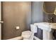 Small powder room with dark grey walls, pedestal sink, and modern fixtures at 5687 Dayton St, Denver, CO 80238