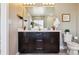 Modern bathroom with dual sinks, dark wood vanity, and glass-enclosed shower in the background at 5687 Dayton St, Denver, CO 80238