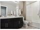 Well-lit bathroom featuring a double sink vanity with black cabinets, white countertops, and modern fixtures at 5687 Dayton St, Denver, CO 80238