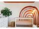 Bright Bedroom featuring a white crib, neutral walls, and a large plant at 5687 Dayton St, Denver, CO 80238