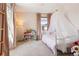 A charming bedroom featuring a white canopy bed and neutral walls, bathed in natural light from the nearby window at 5687 Dayton St, Denver, CO 80238