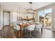 Bright dining area features a wooden table and chairs with an open layout to the kitchen and sliding glass door at 5687 Dayton St, Denver, CO 80238