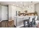 Bright kitchen features white cabinets, stainless steel appliances, and a large island with barstool seating at 5687 Dayton St, Denver, CO 80238