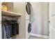 Functional laundry room with a stacked washer and dryer, complemented by a shelf and rod for hanging clothes at 5687 Dayton St, Denver, CO 80238