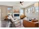 Bright living room features a fireplace with stone accent wall, ceiling fan, and lots of natural light at 5687 Dayton St, Denver, CO 80238