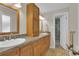Bathroom featuring double sinks, tile floors, and a shower behind a white door at 7504 E Jefferson Dr, Denver, CO 80237