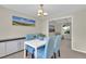 Bright dining area features modern light fixture, scenic wall art and contemporary white table at 7504 E Jefferson Dr, Denver, CO 80237