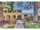 Charming two-story brick home with a blue double-door entry, arched porch, and well-maintained landscaping at 7504 E Jefferson Dr, Denver, CO 80237