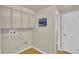 Functional laundry room with neutral paint, storage cabinetry, and convenient access at 7504 E Jefferson Dr, Denver, CO 80237