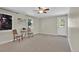 Light filled living room has neutral paint and carpet, ceiling fan, and two windows at 7504 E Jefferson Dr, Denver, CO 80237