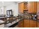 Wet bar features rich cabinetry, a black countertop, and a wine rack at 4775 S Anaheim Ct, Aurora, CO 80015