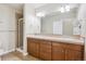 Well-lit bathroom with dual sinks, wooden cabinetry, and a glass-enclosed shower, perfect for a refreshing start at 4775 S Anaheim Ct, Aurora, CO 80015