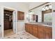 Bathroom featuring double vanity sinks, granite counters, and walk-in closet at 4775 S Anaheim Ct, Aurora, CO 80015