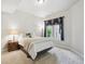 Cozy bedroom featuring a comfortable bed, side table with lamp, and natural light from the window at 4775 S Anaheim Ct, Aurora, CO 80015
