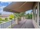 Expansive wooden deck with awning features iron railings and views of the neighborhood and trees at 4775 S Anaheim Ct, Aurora, CO 80015