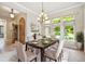 Dining room with a dark wood table, light upholstered chairs and lots of natural light from the windows at 4775 S Anaheim Ct, Aurora, CO 80015