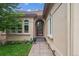 Inviting entrance with an arched doorway, decorative windows, and a pathway lined with tasteful landscaping at 4775 S Anaheim Ct, Aurora, CO 80015