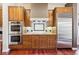 Close up of stainless steel appliances, wooden cabinetry, and granite countertops in this updated kitchen at 4775 S Anaheim Ct, Aurora, CO 80015