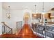Open-concept view of an updated kitchen with stainless steel appliances, granite countertops, and hardwood floors at 4775 S Anaheim Ct, Aurora, CO 80015