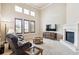 Bright living room featuring a fireplace, high ceilings, and large windows offering natural light at 4775 S Anaheim Ct, Aurora, CO 80015