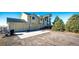 View of a yellow home with a two-car garage, basketball hoop, and a long driveway in rural surroundings at 7440 S Shenandoah Dr, Elizabeth, CO 80107