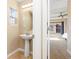 Powder room with pedestal sink and tile flooring next to an open door into the bedroom with many windows at 9228 Sori Ln, Highlands Ranch, CO 80126