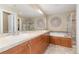 Bright bathroom featuring double sinks, a soaking tub, and a separate glass-enclosed shower with stylish tile surround at 9228 Sori Ln, Highlands Ranch, CO 80126