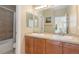 Bright bathroom featuring double sinks, a soaking tub/shower combination, and stylish wall art at 9228 Sori Ln, Highlands Ranch, CO 80126